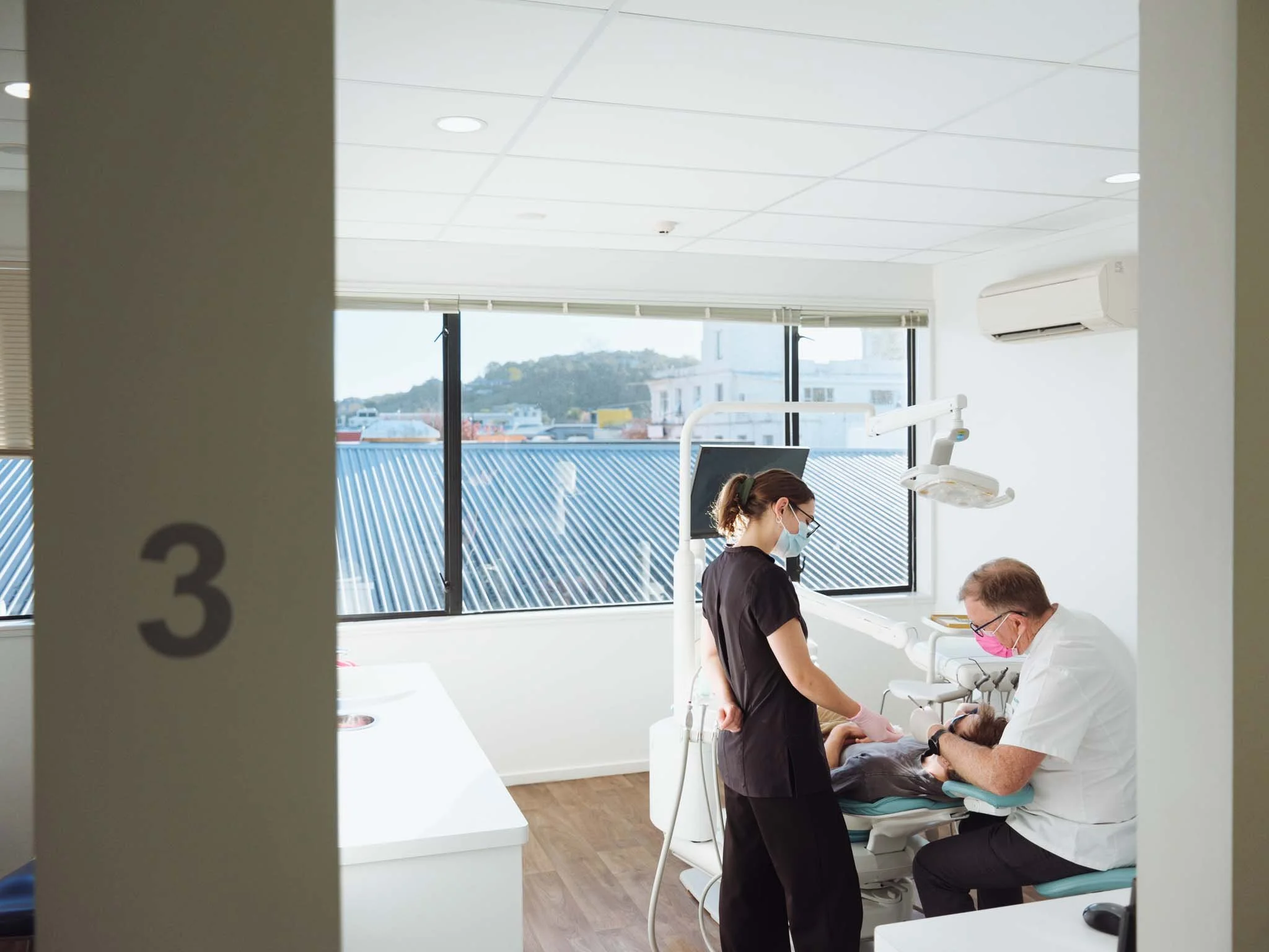 Gerry Quin and dental assistant perform dental exam at Quin Dental in Nelson, New Zealand.