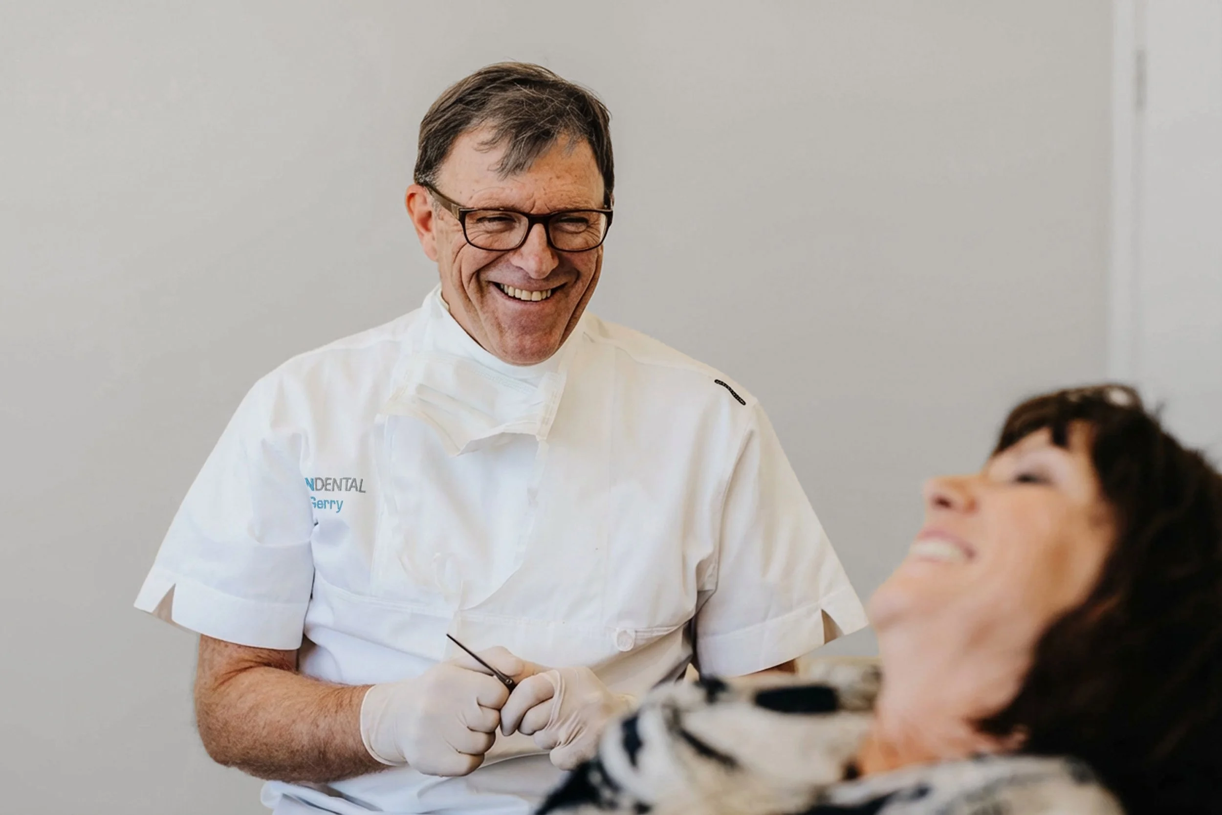 Gerry Quin, Dentist, attending to a female patient at Quin Dental, Nelson, New Zealand