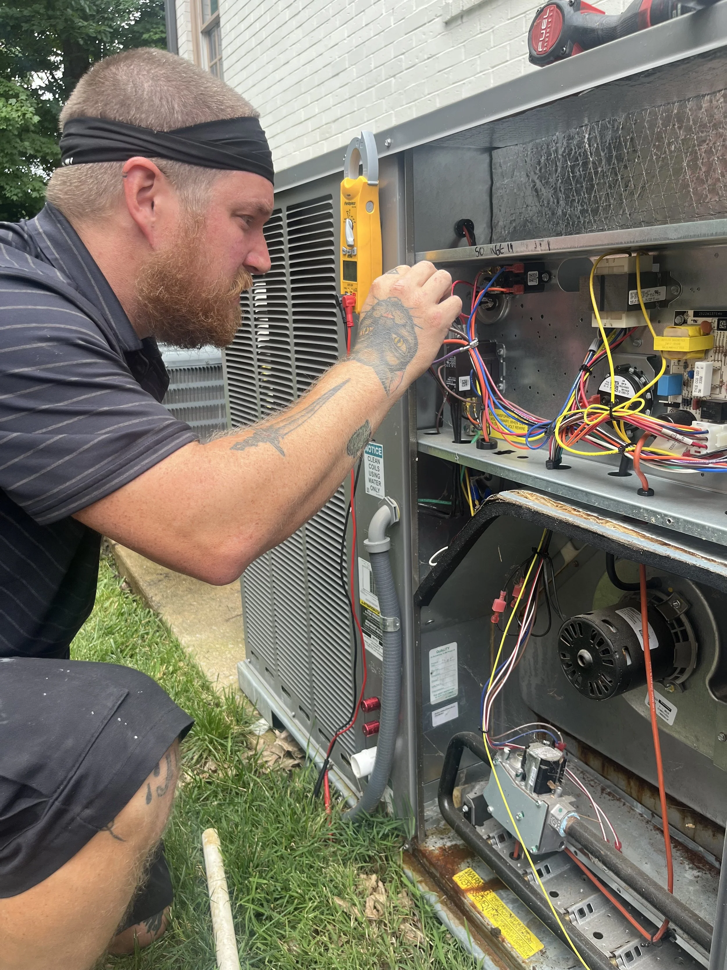 HVAC technician performing preventative maintenance, electrical diagnostics, and system troubleshooting on a residential heating and cooling system