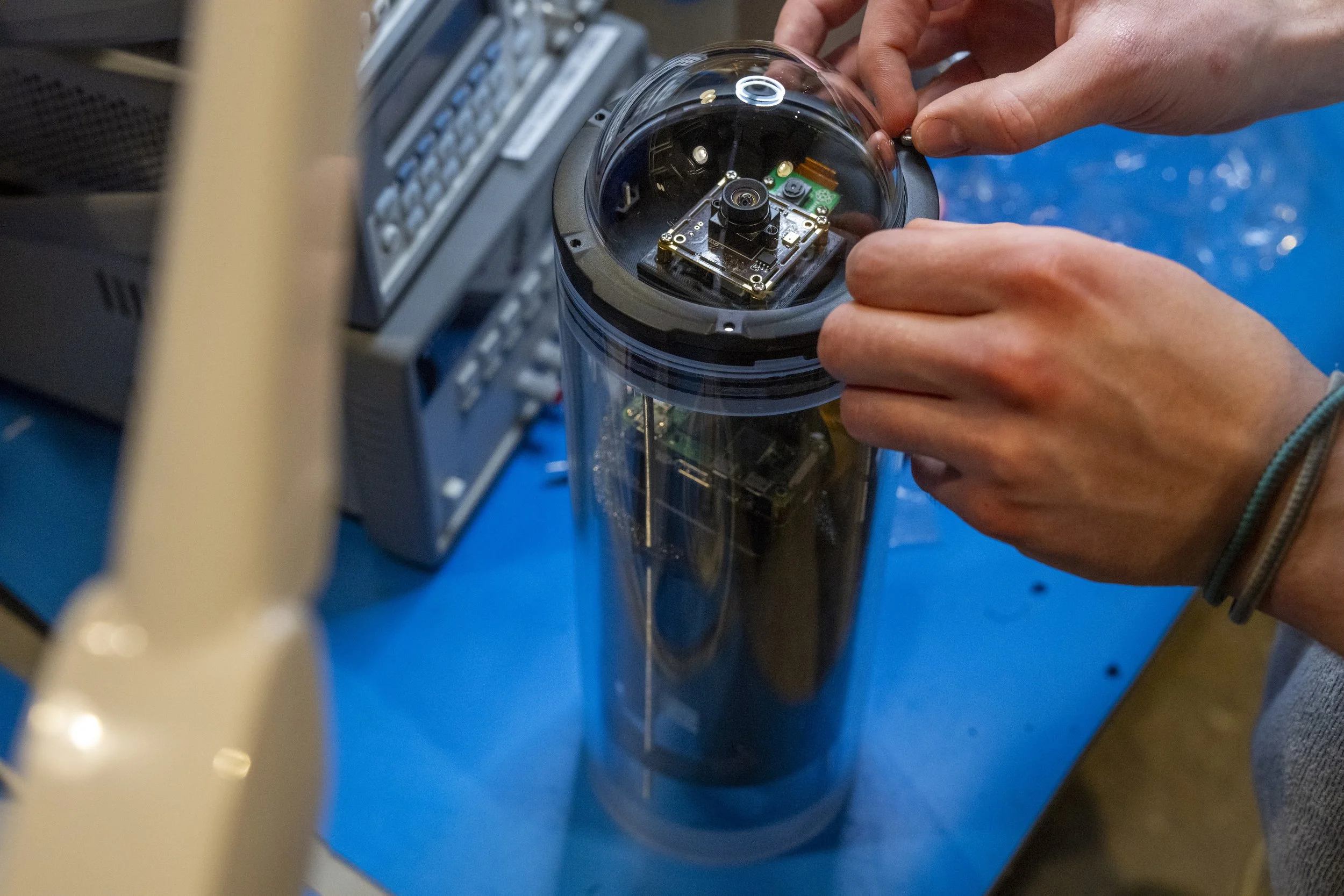 hands working on assembling a Terrapin 1 aquatic camera trap, or underwater trail camera,