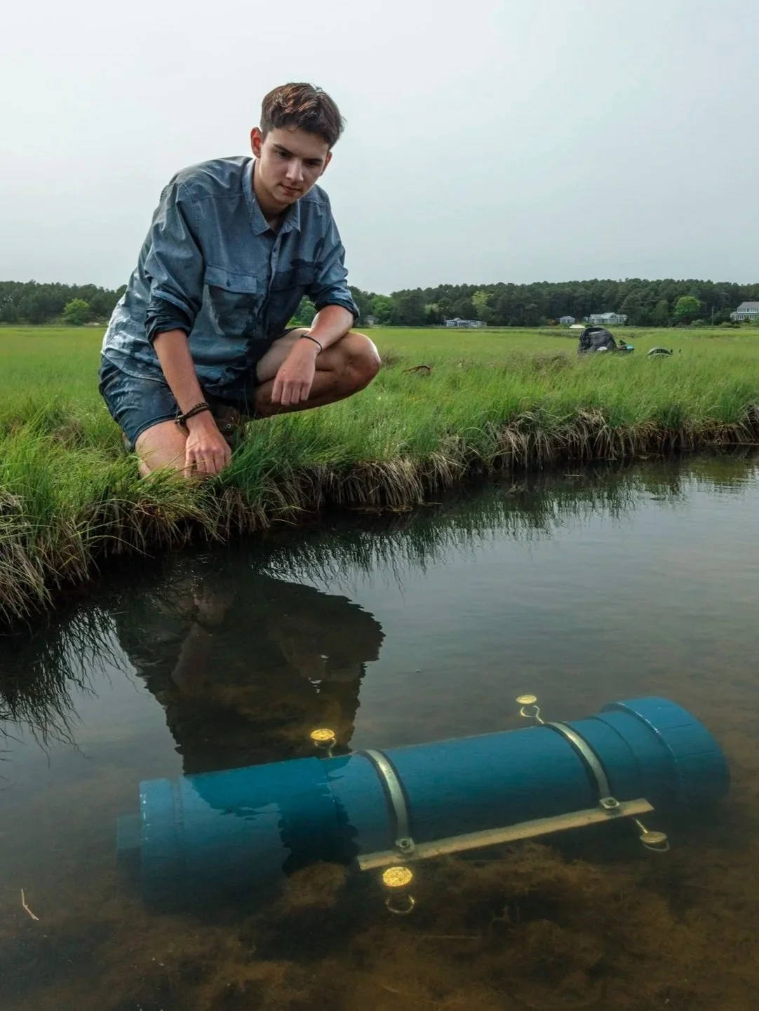 National Geographic Explorer Soren Goldsmith deploying a Terrapin 1 aquatic camera trap, or underwater trail camera, in a salt marsh in Massachusetts New England.