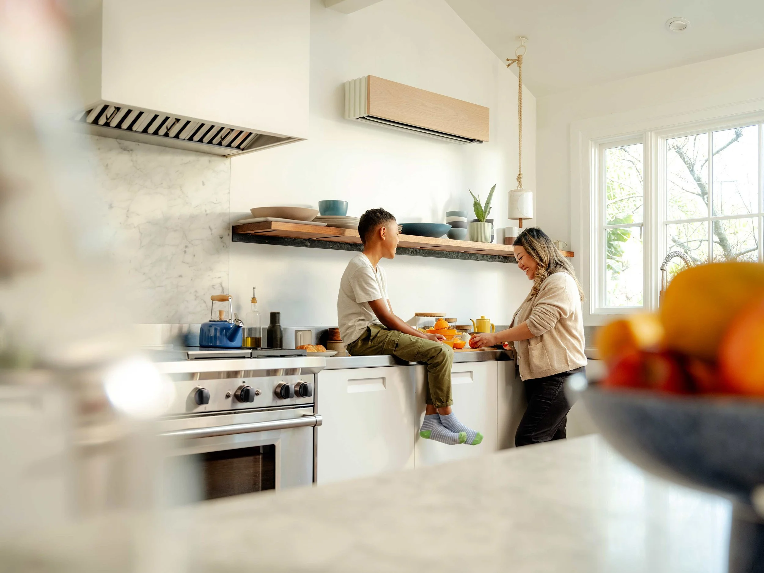 Sleek wood-grain Quilt ductless heat pump indoor unit seamlessly integrated into a modern kitchen design.
