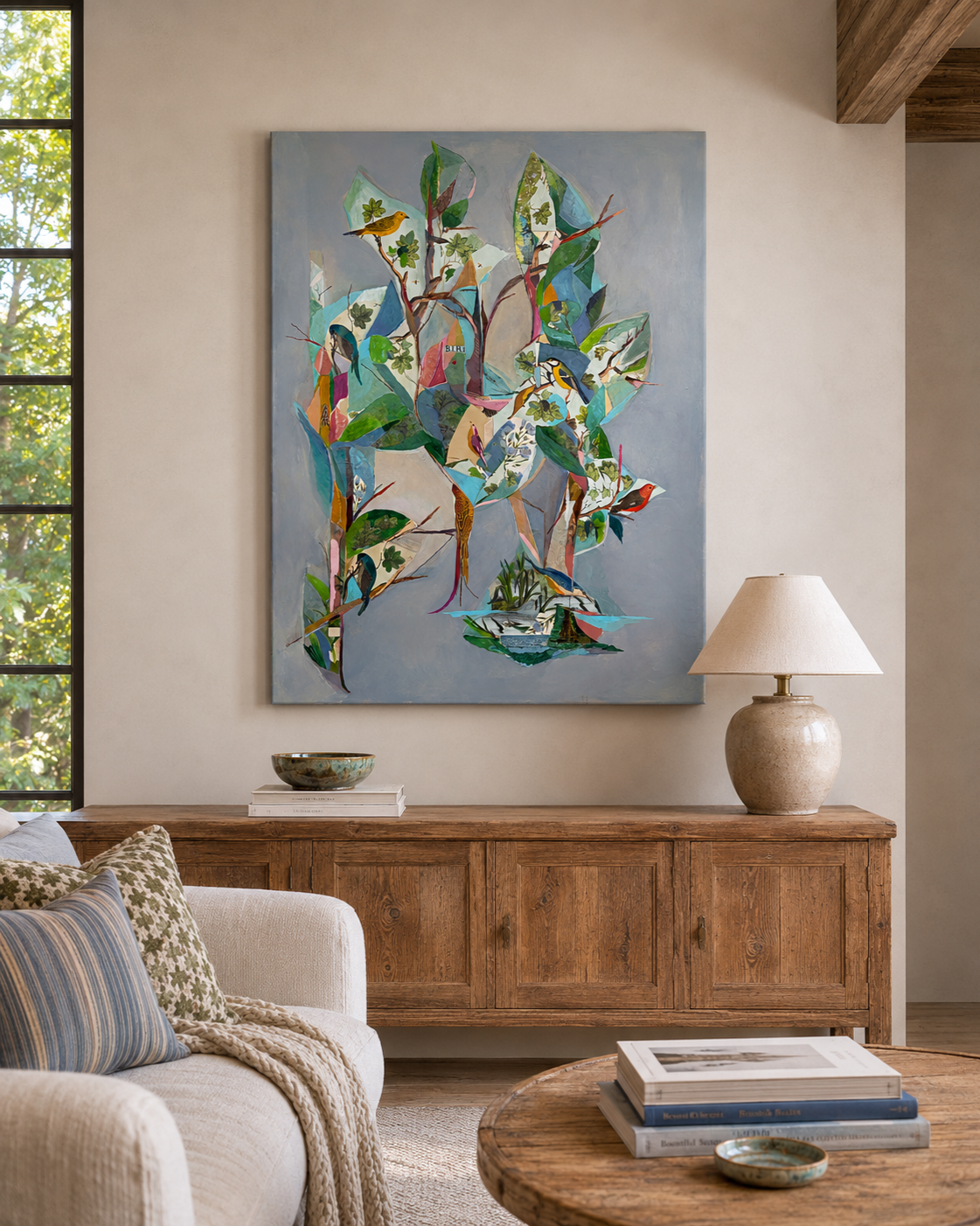 Colorful painting of birds and leaves on a wall in a living room with wooden furniture and a lamp.