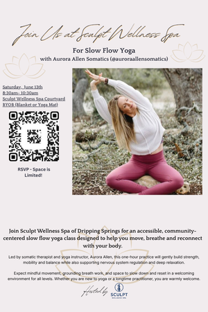 A woman practicing yoga outdoors in a wooded area, sitting cross-legged with her arms raised and wearing a white top and pink leggings.