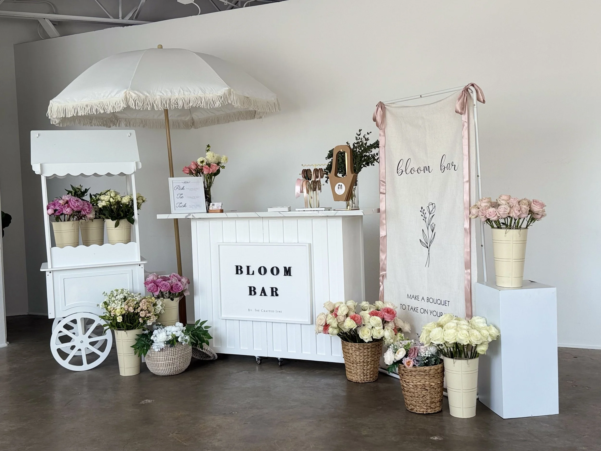 Indoor white bloom bar cart styled with fresh florals and signage in Colorado