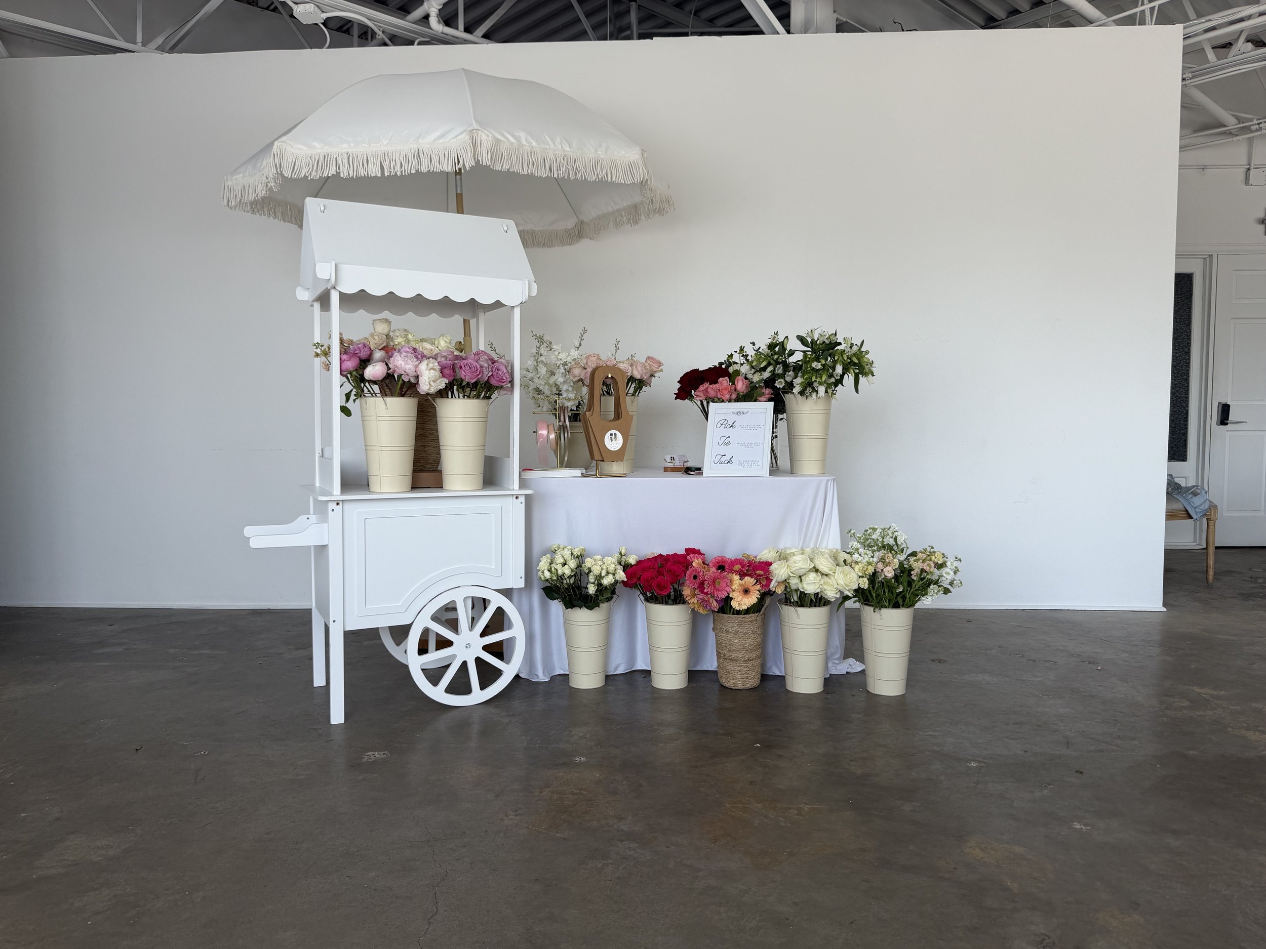 White wooden flower cart filled with mixed blooms at a Colorado event