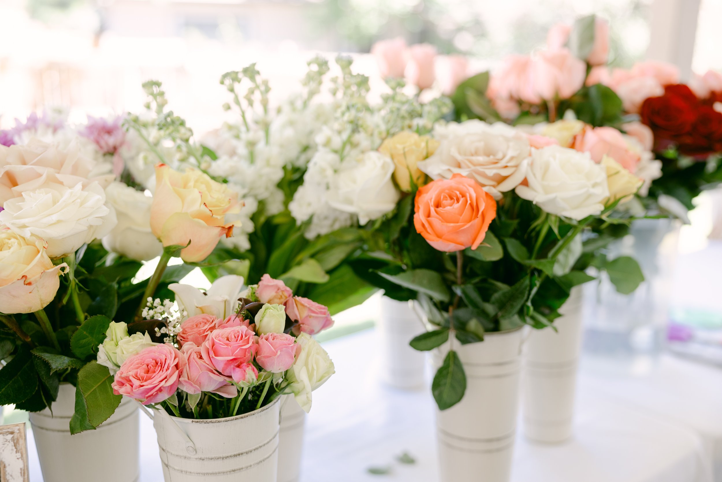 Petite pink and cream take-home bouquets in white vases at a Colorado bloom bar