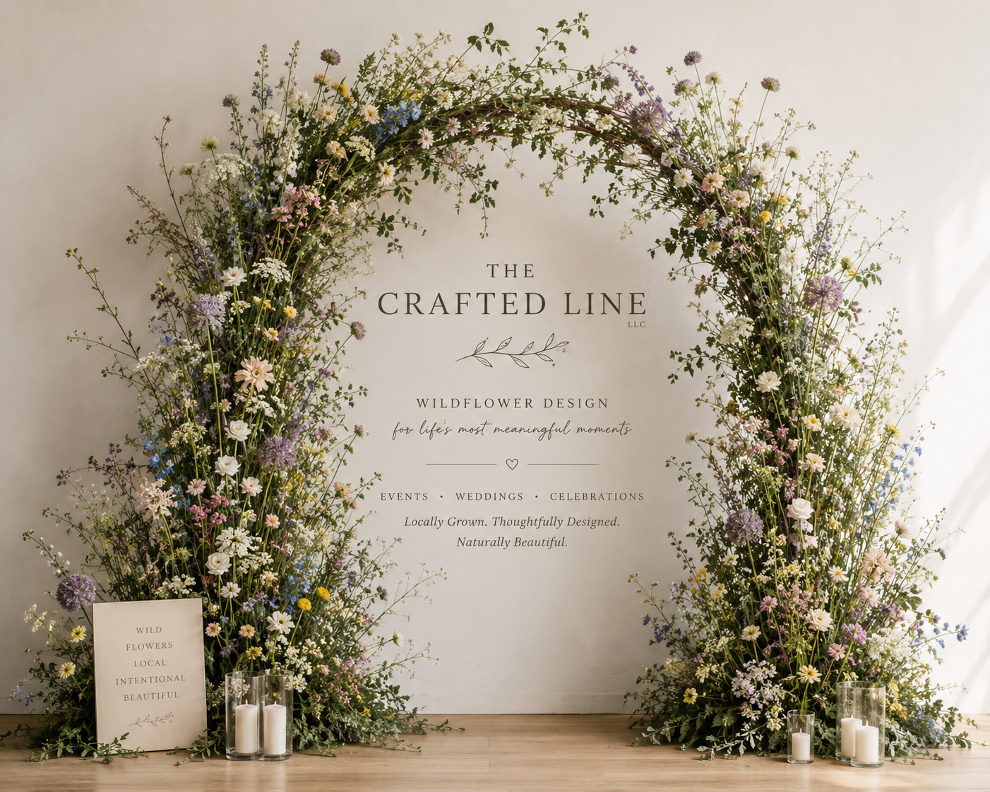 Greenery-covered arch with branded Crafted Line sign at a Colorado wedding