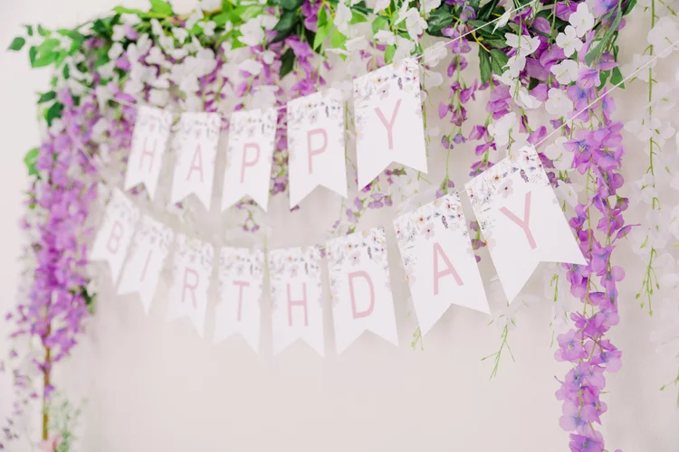 Purple and white flower garlands with Happy Birthday banner