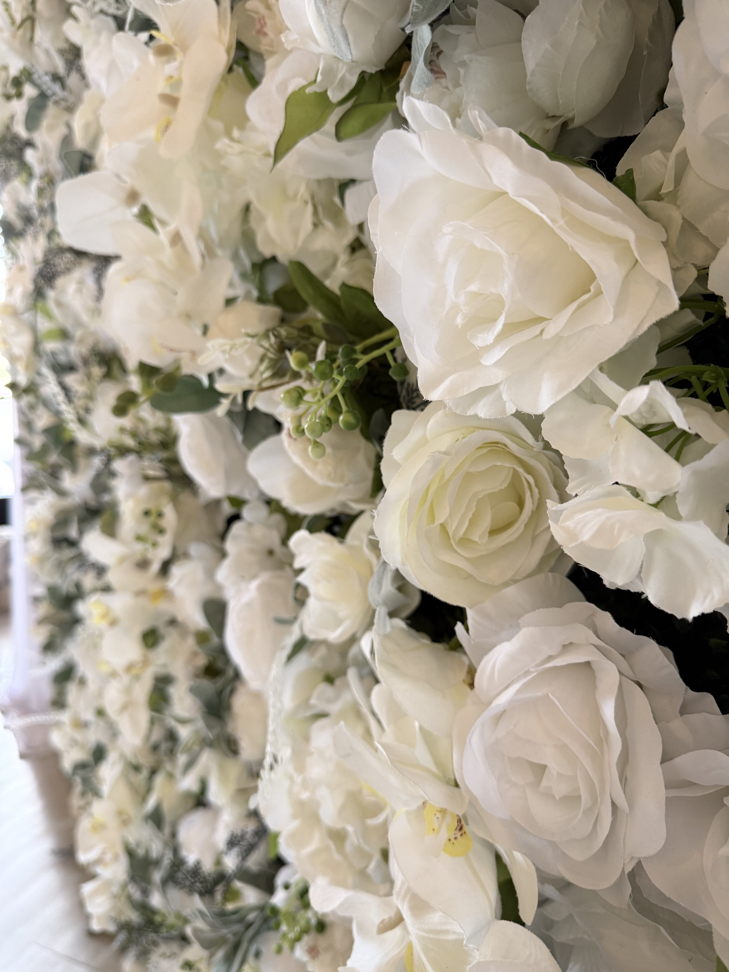 Close-up of a white rose and greenery floral wall panel in Colorado