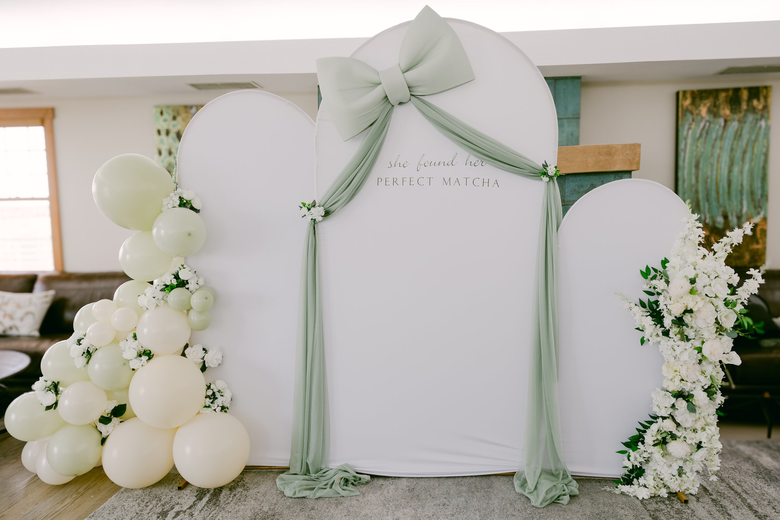 White draped arch with sage accents and balloon garland in Colorado
