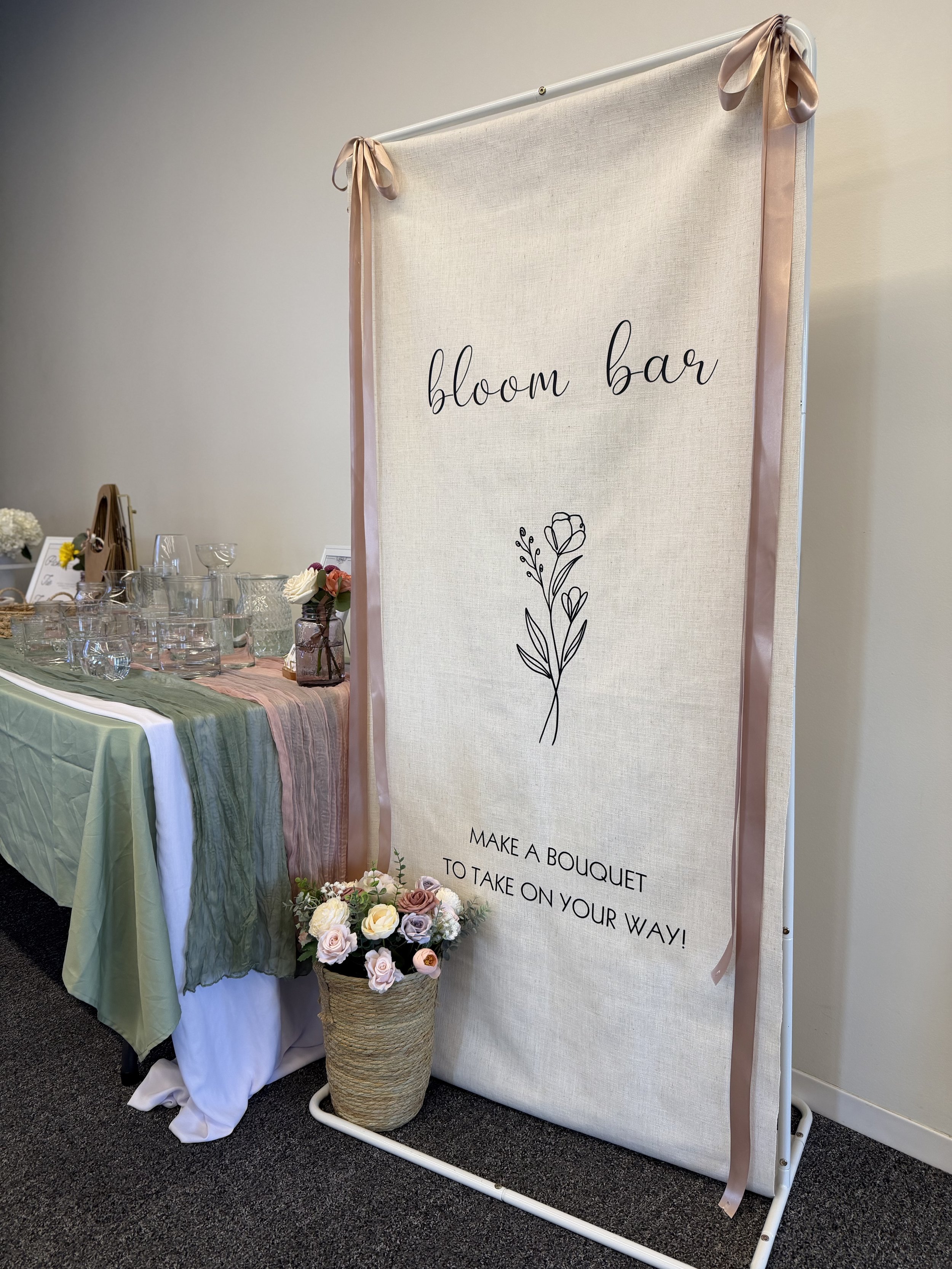 Draped bloom bar backdrop with hanging blooms at an outdoor Colorado pop-up