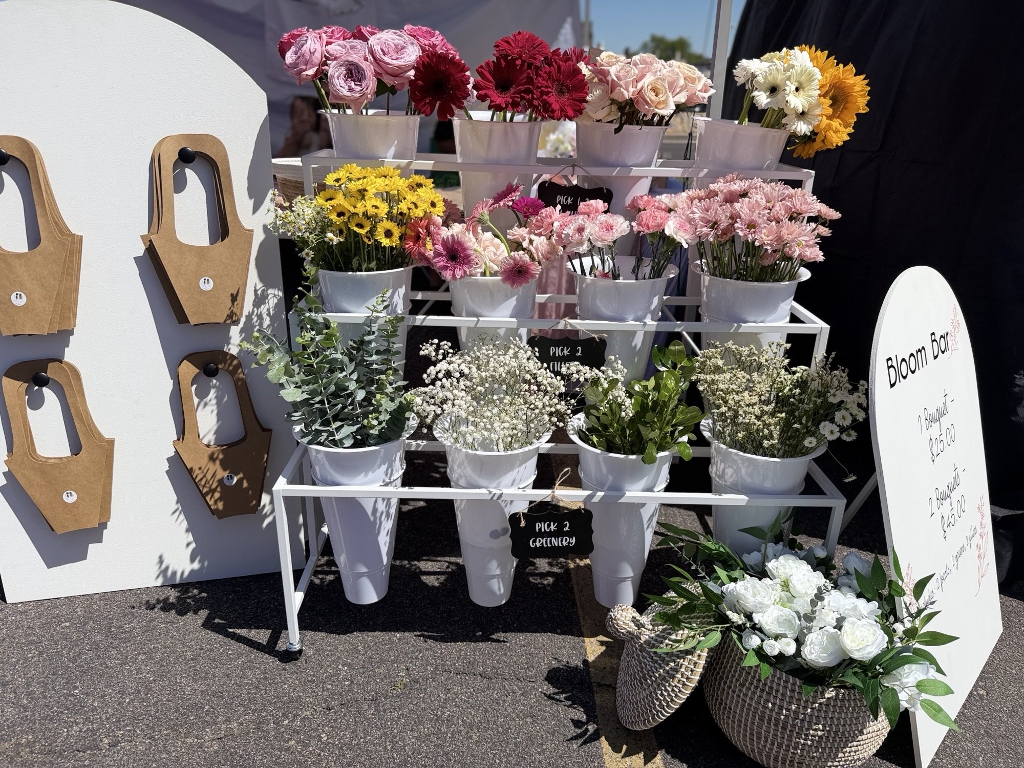 White display cart filled with fresh stems and greenery at a Colorado market