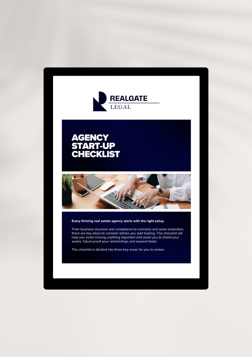 Tablet displaying RealGATE Legal Agency Start-up Checklist with text and an image of a person typing on a laptop