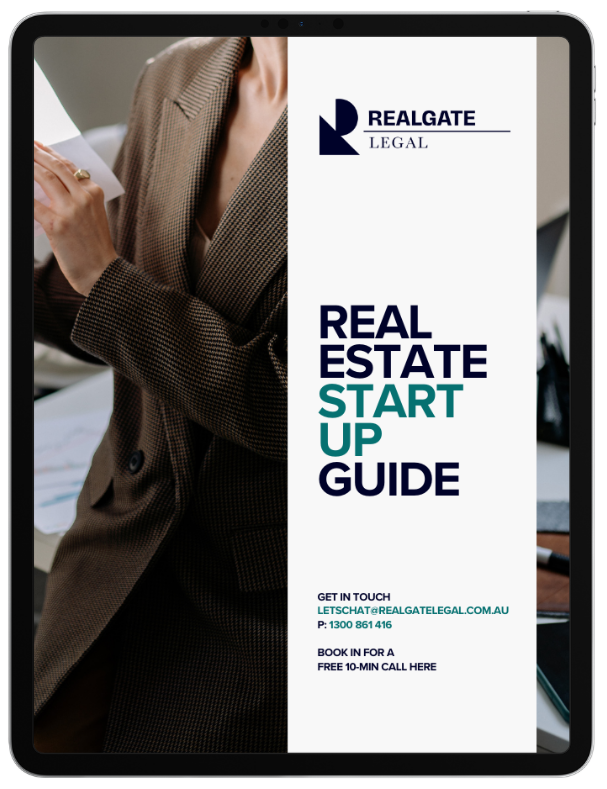 A person in a brown checkered blazer holding a document, with a digital brochure for 'Realgate Legal' on the screen, titled 'Real Estate Startup Guide', providing contact information and a free consultation offer.
