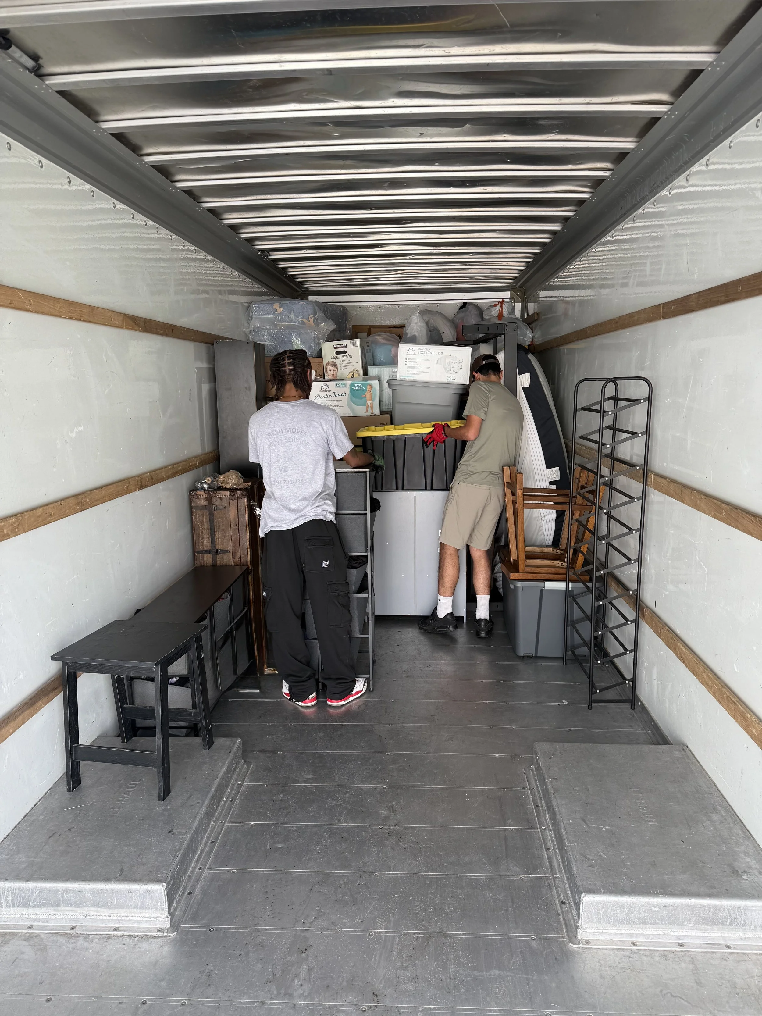 A photo of professional movers loading a 26’’ truck.