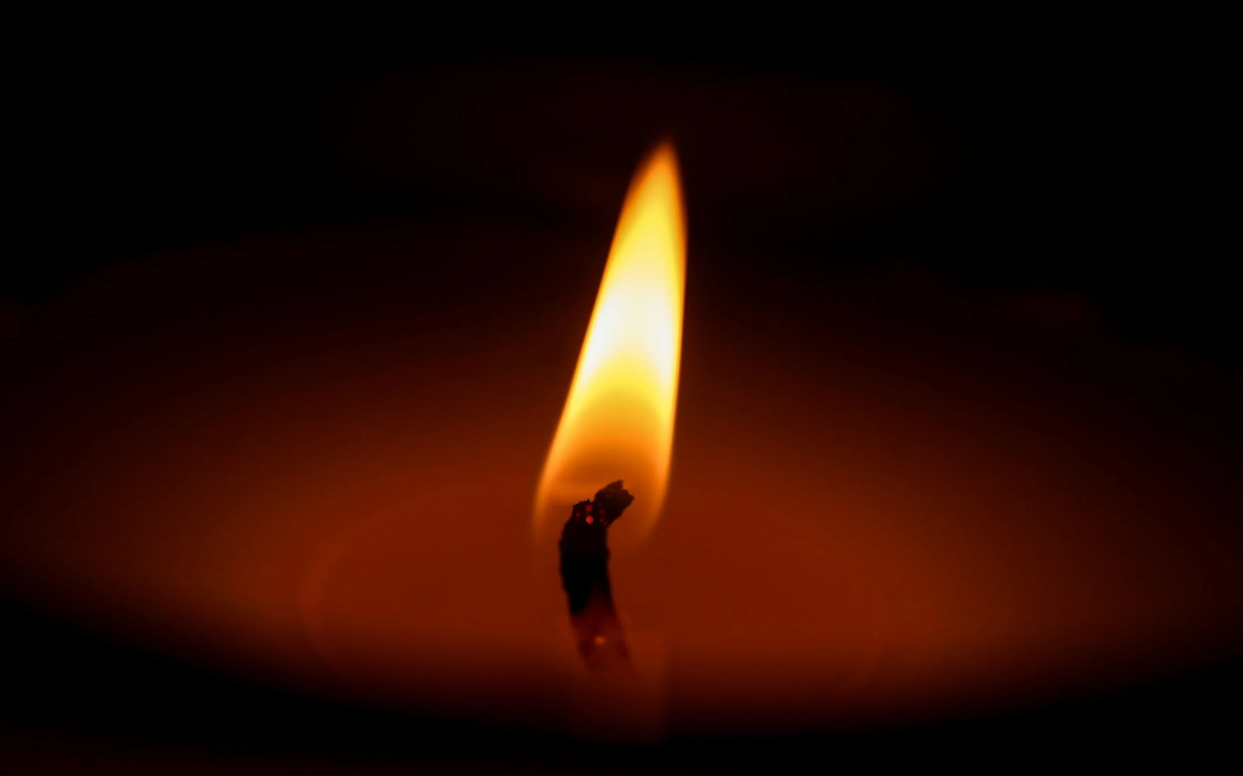 Lit match igniting a candle flame, symbolizing transformation, illumination, and the Ignis Knosis journey of initiation.