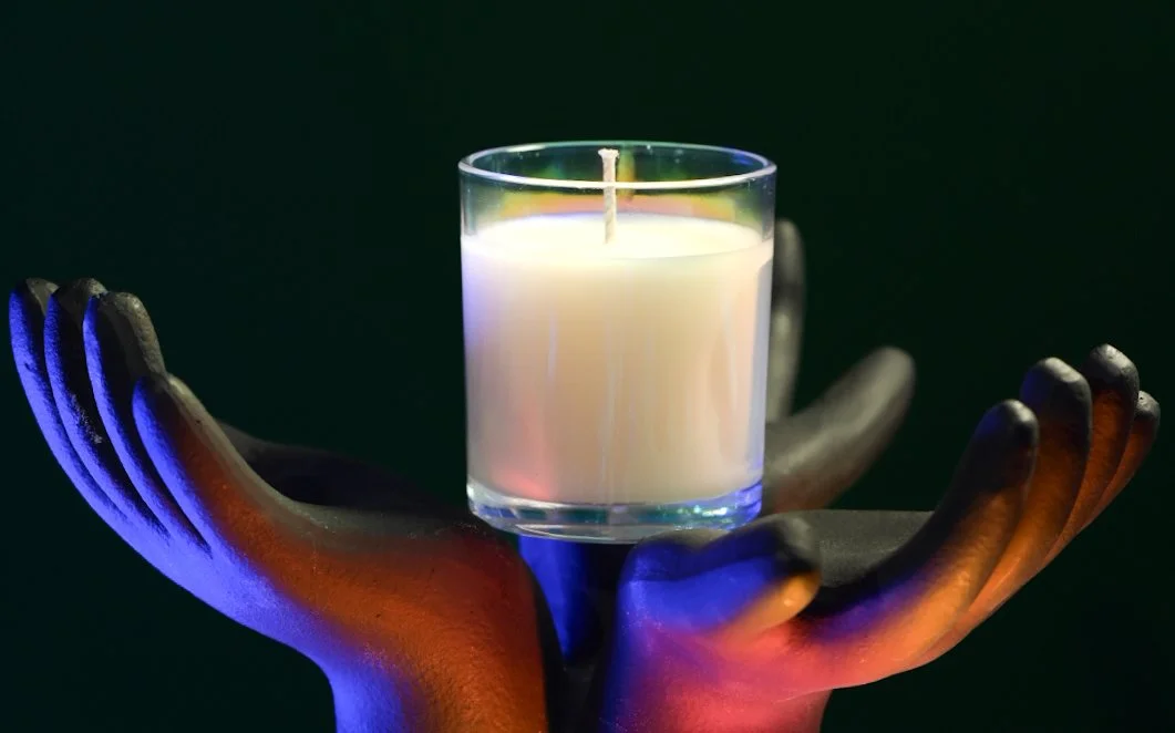 Ignis Knosis candle held in offering, symbolizing intention, illumination, and the transformative power of ritual.