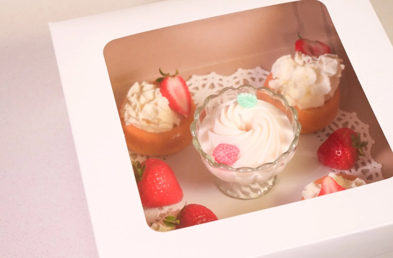 Curious Confections Strawberry Cheesecake candle gift presentation featuring handcrafted dessert-inspired artistry and sweet bakery fragrance notes.