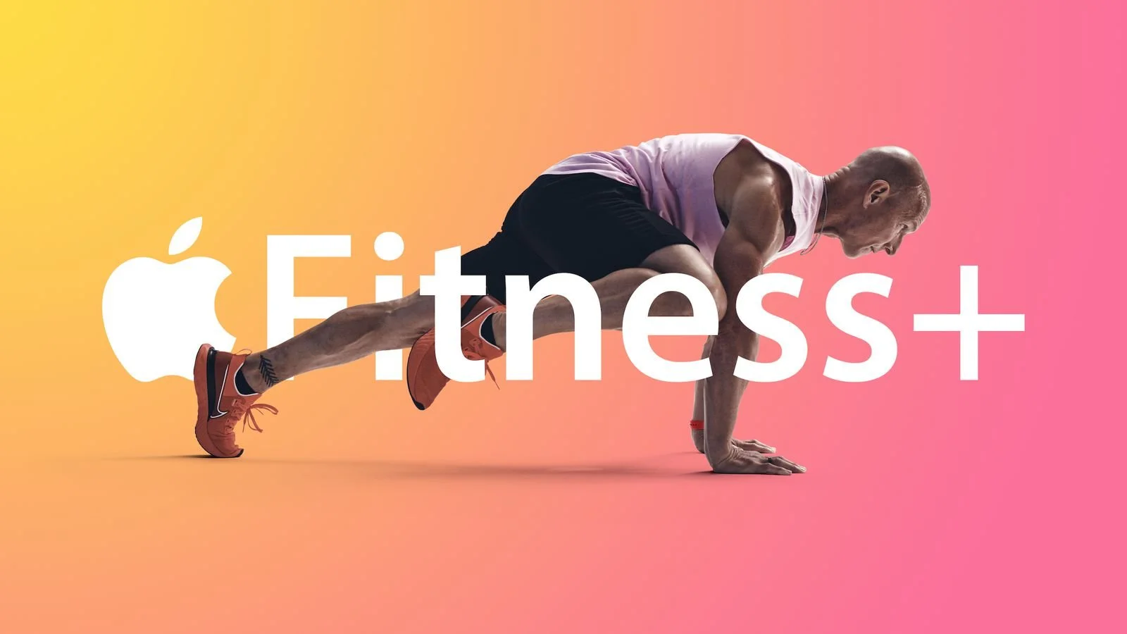A man in workout clothes is in a push-up position against a pink and yellow gradient background. The words "Apple Fitness+" are overlaid in white text, with the Apple logo.