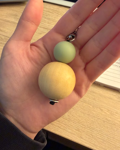 hand holding a example size of a newborn and 3 month old baby stomach