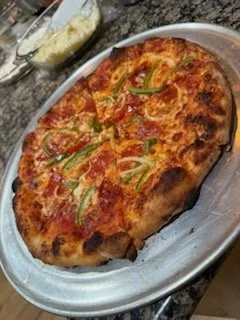 Baked lasagna with cheese, tomato sauce, and green peppers on a metal tray