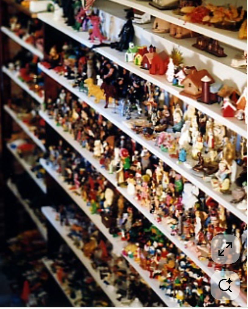 Multiple shelves filled with colorful miniature figurines and decorations, likely in a store or collectible shop.