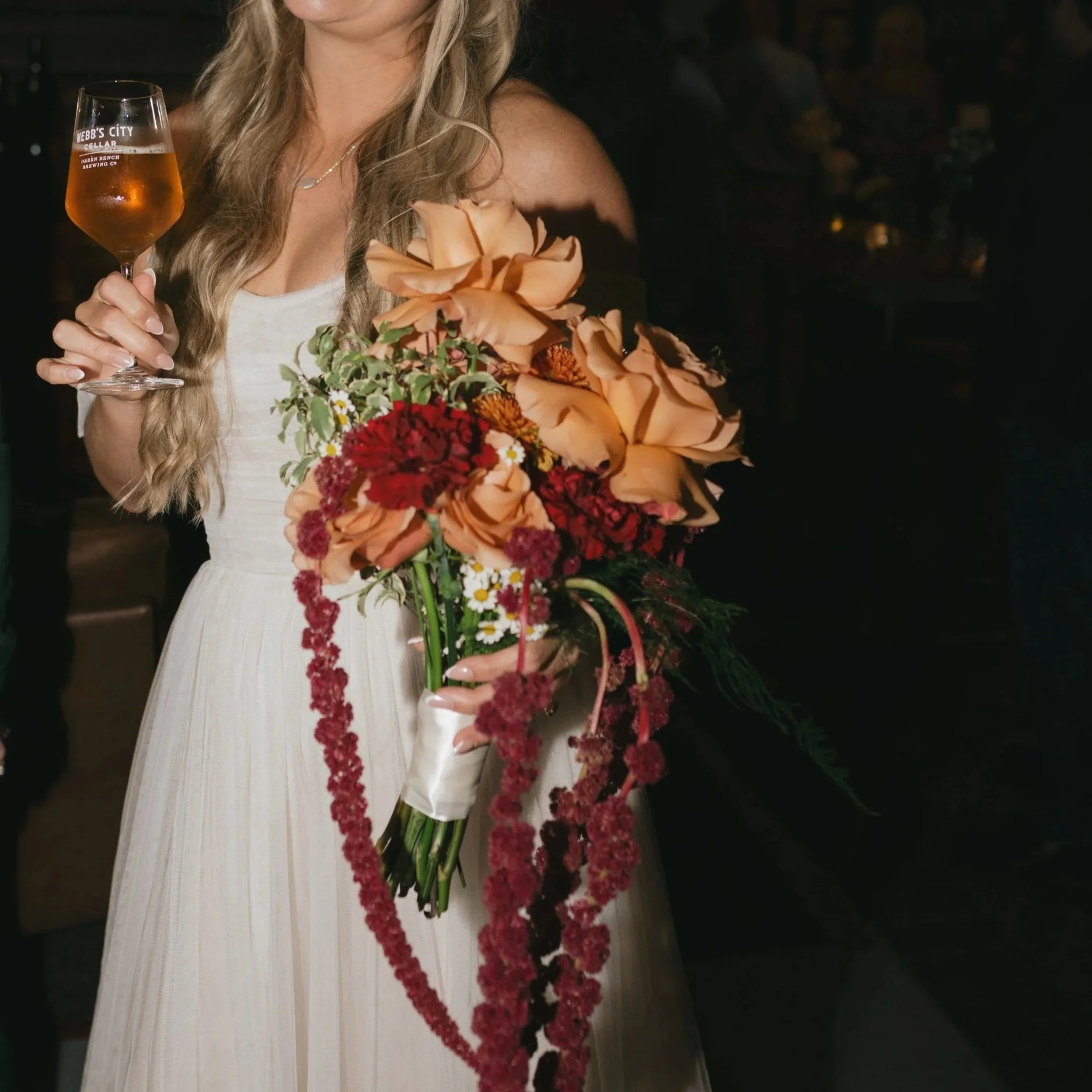 Fun and whimsical bridal bouquet with refluxed roses and long hanging amaranthus.