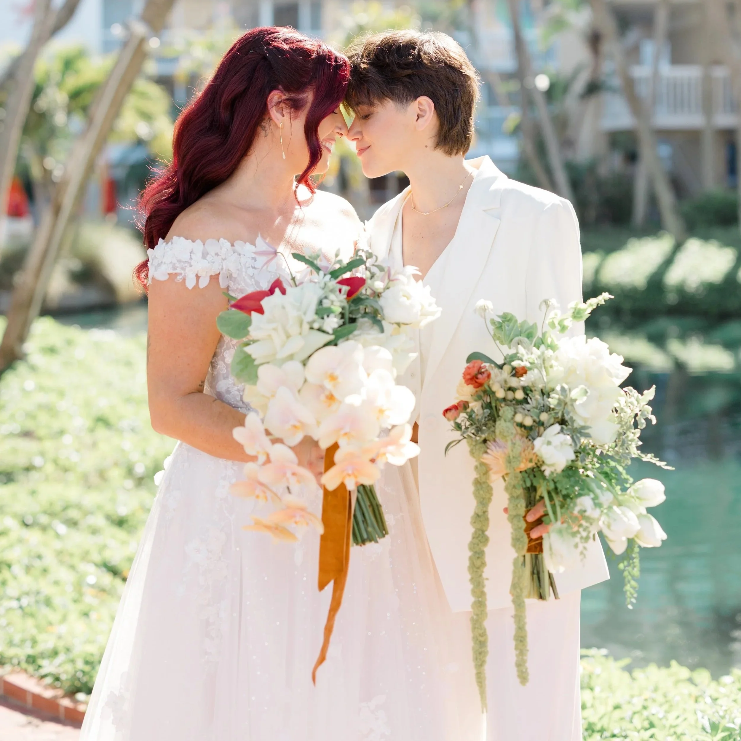 LGBTQ+ wedding with two luscious and textural bridal bouquets including cascading orchids and tulips, and a variety of wild flowers.