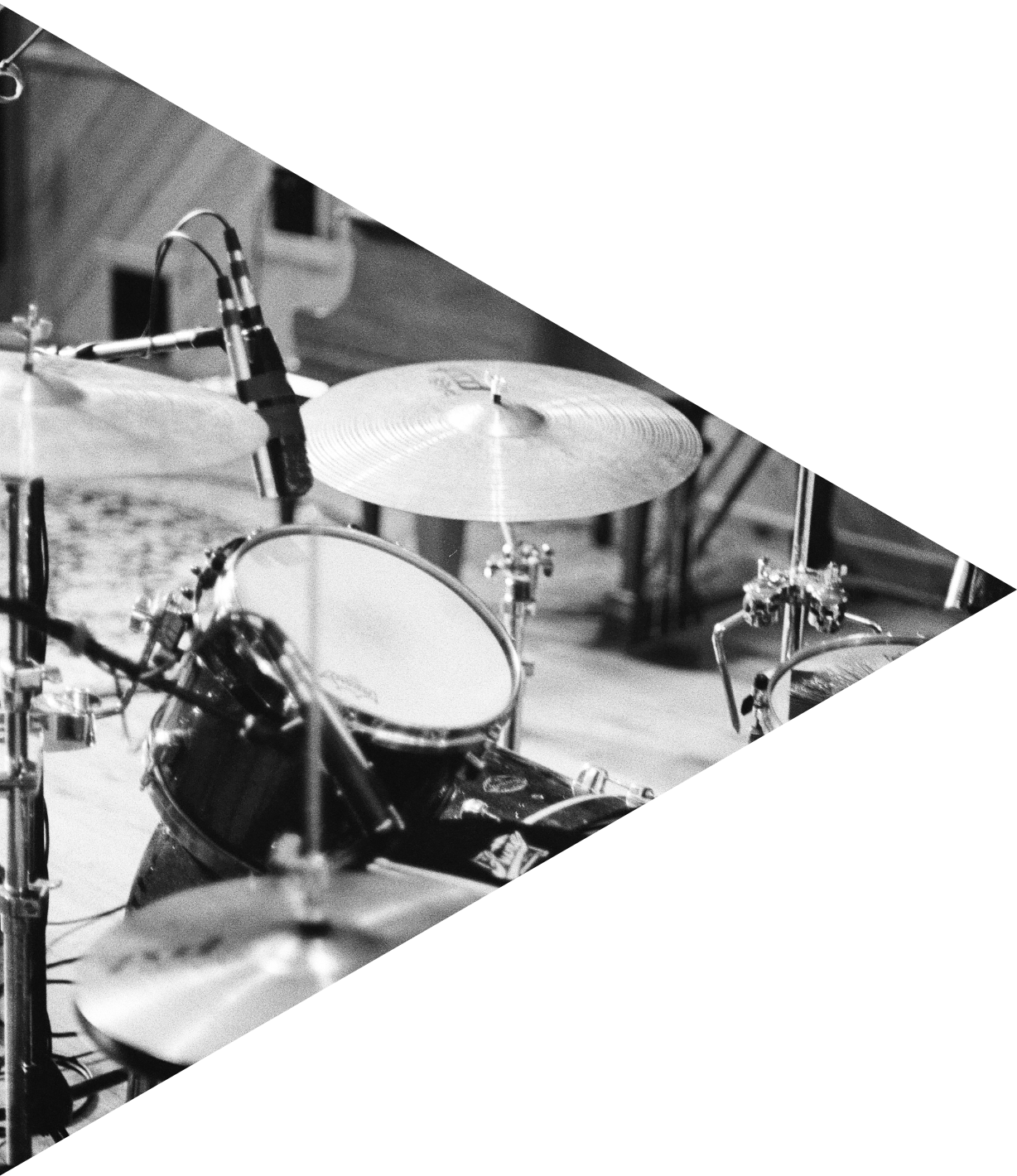 Black and white photo of a drum set including cymbals and drums positioned in a recording studio.