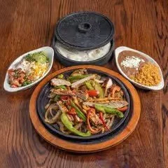Close-up of a serving of beef stew with vegetables, served with rice and steamed broccoli and cabbage.