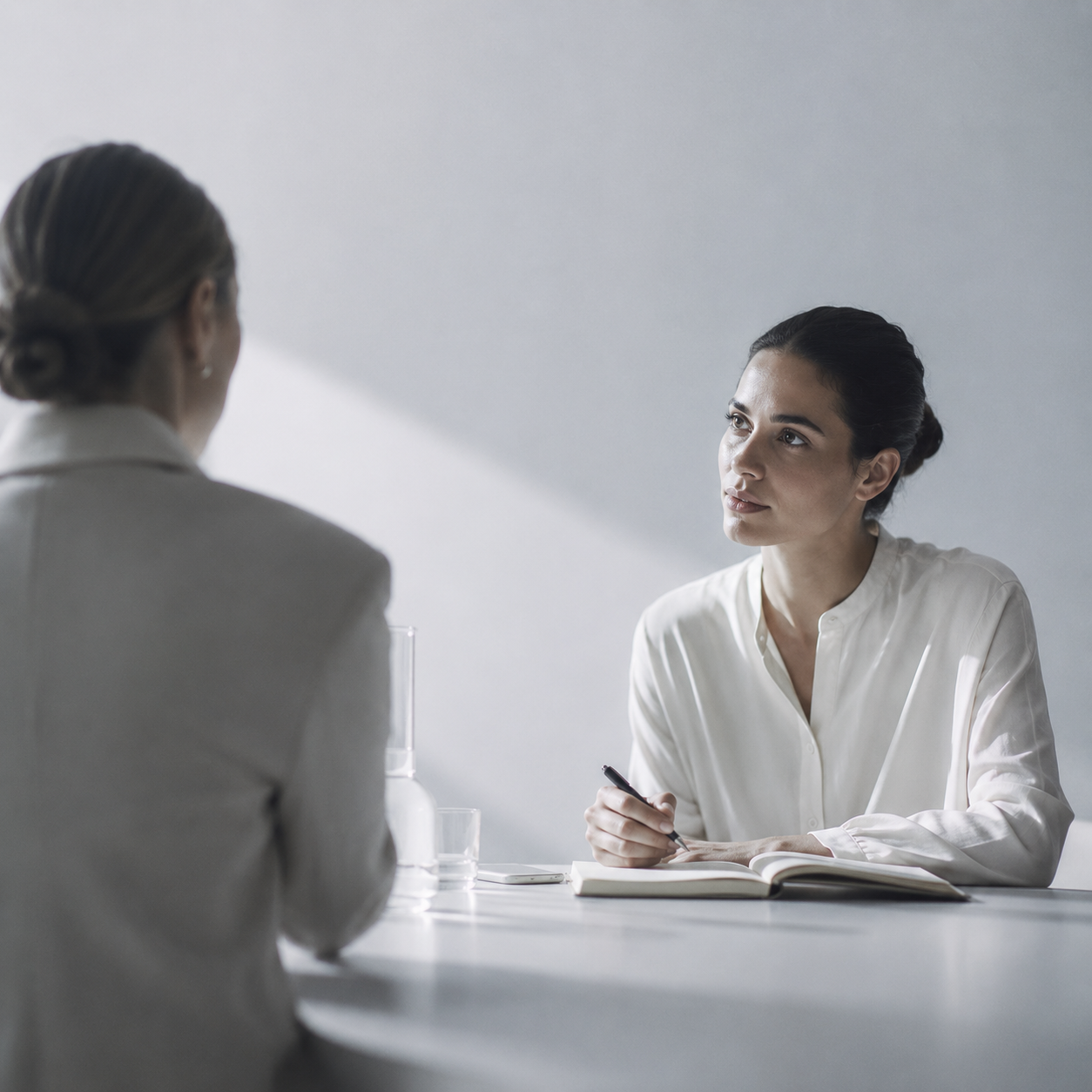Two women in a consultation meeting discussing brand goals and brief details.