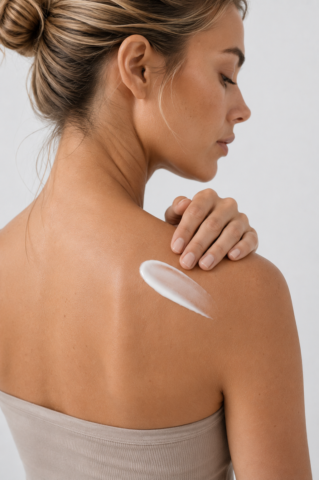 Woman applying lotion to her shoulder, representing a personal care product.