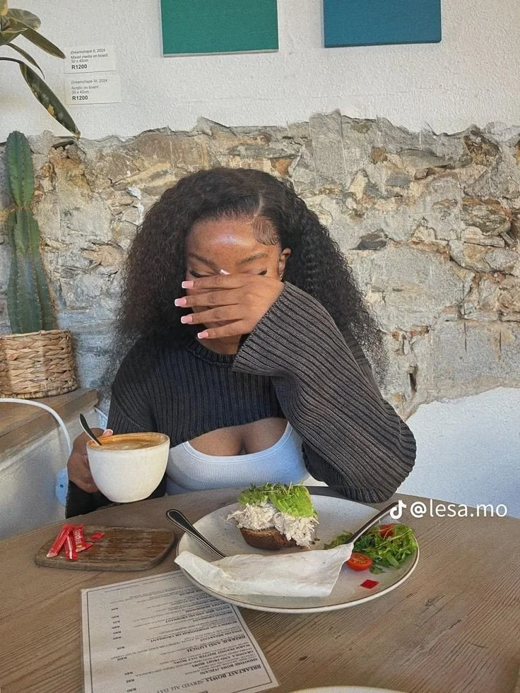 A woman present in a cafe, engaged with the room around her instead of a screen