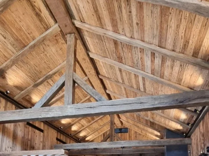Interior view of a wooden roof with exposed beams and planks.