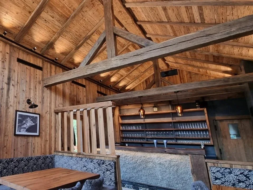 Interior of a rustic wooden barn with a wood-paneled ceiling,
