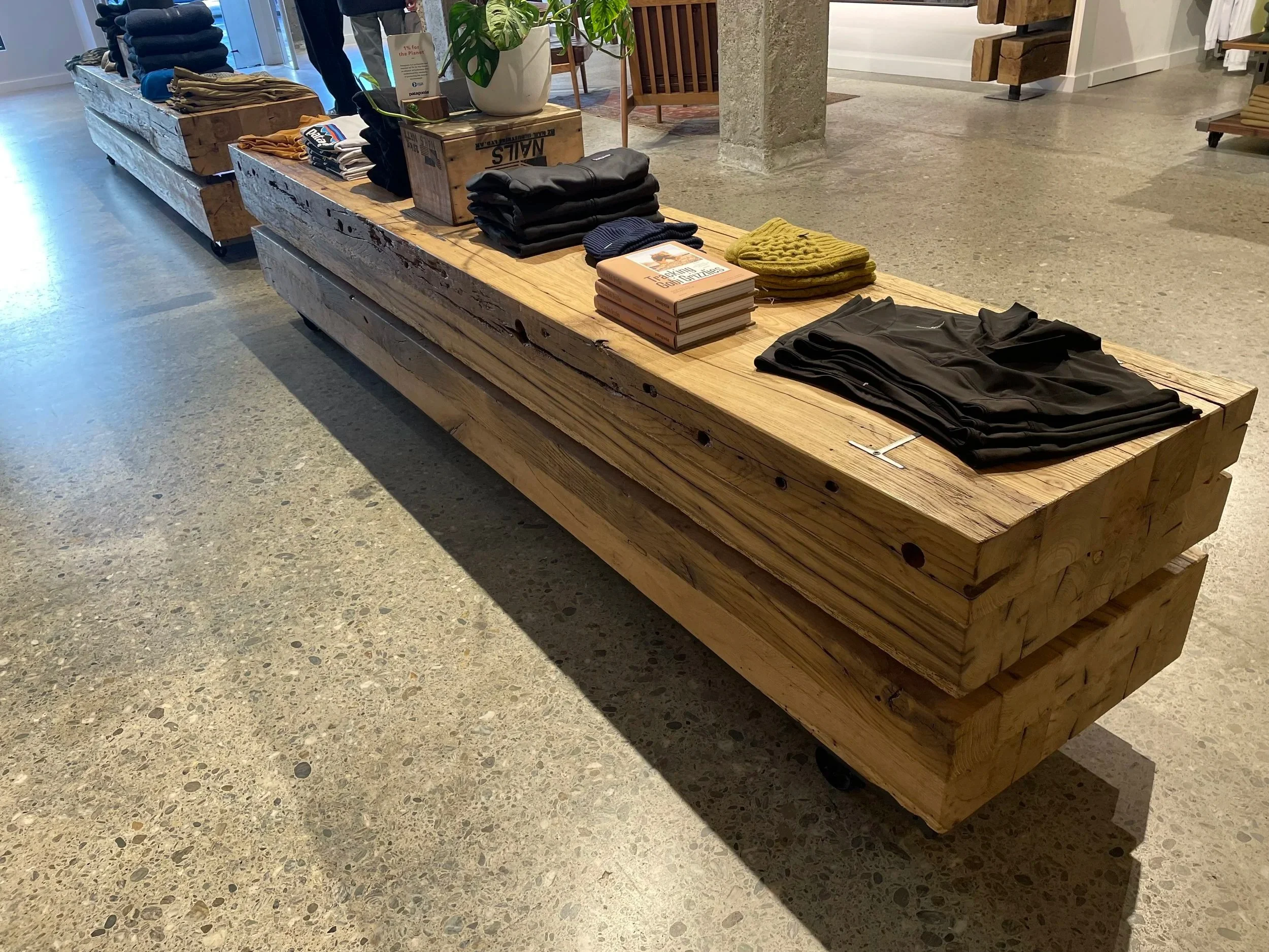 Display objects on a rustic wooden display table inside a retail store.