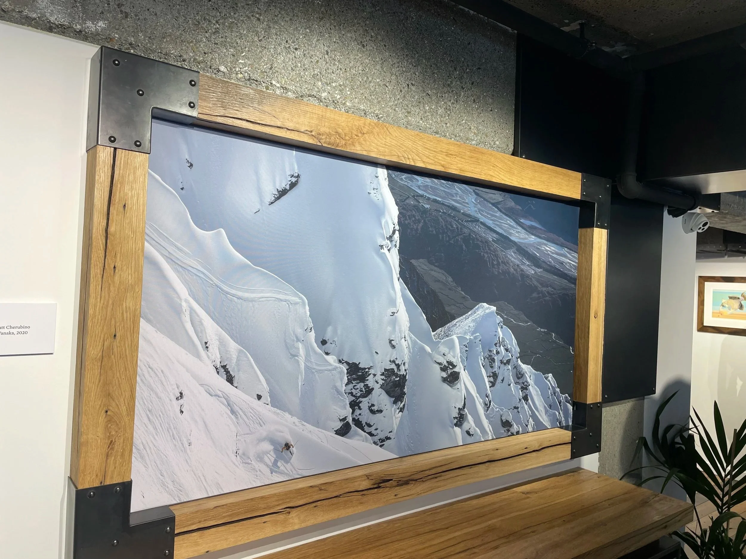 oak wooden frame with metal corner brackets, displayed on a wall.