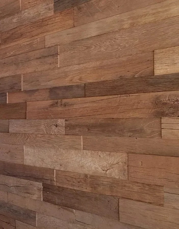 Reclaimed oak cladding boards used as interior wall lining, showing natural grain, tonal variation and aged timber character.
