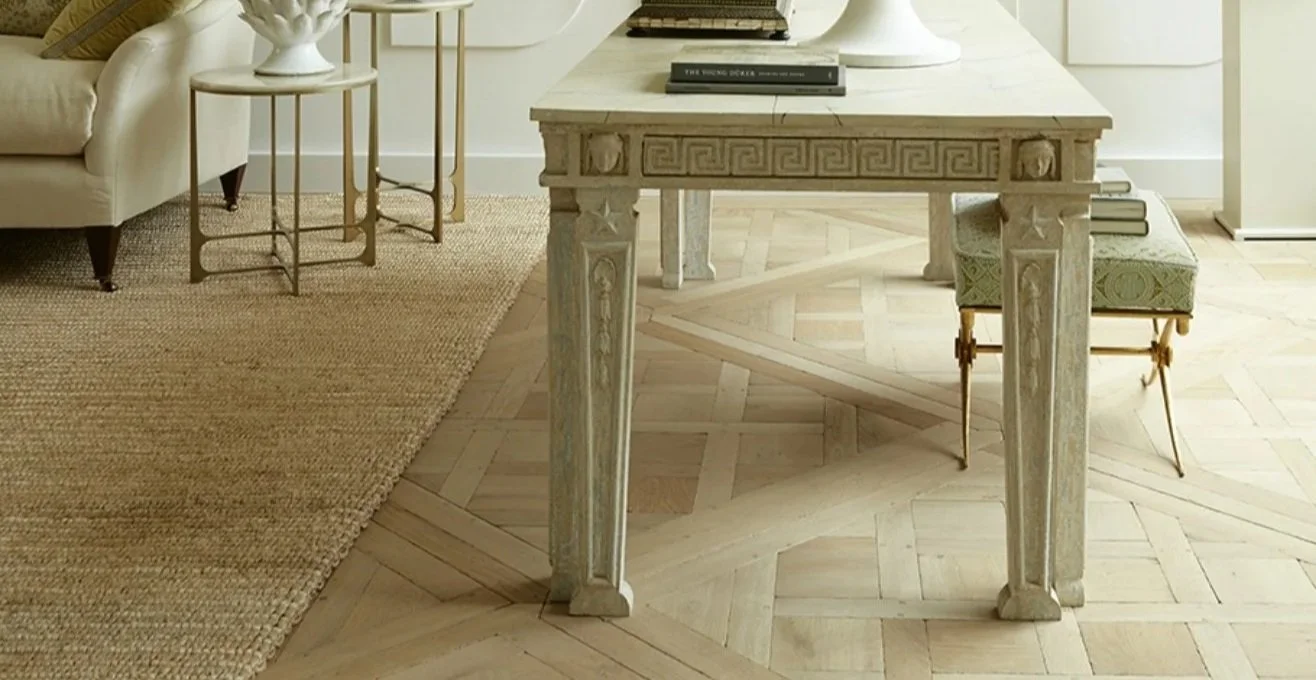 Elegant French oak parquet flooring in a refined interior, showing a soft aged finish and classic patterned layout.