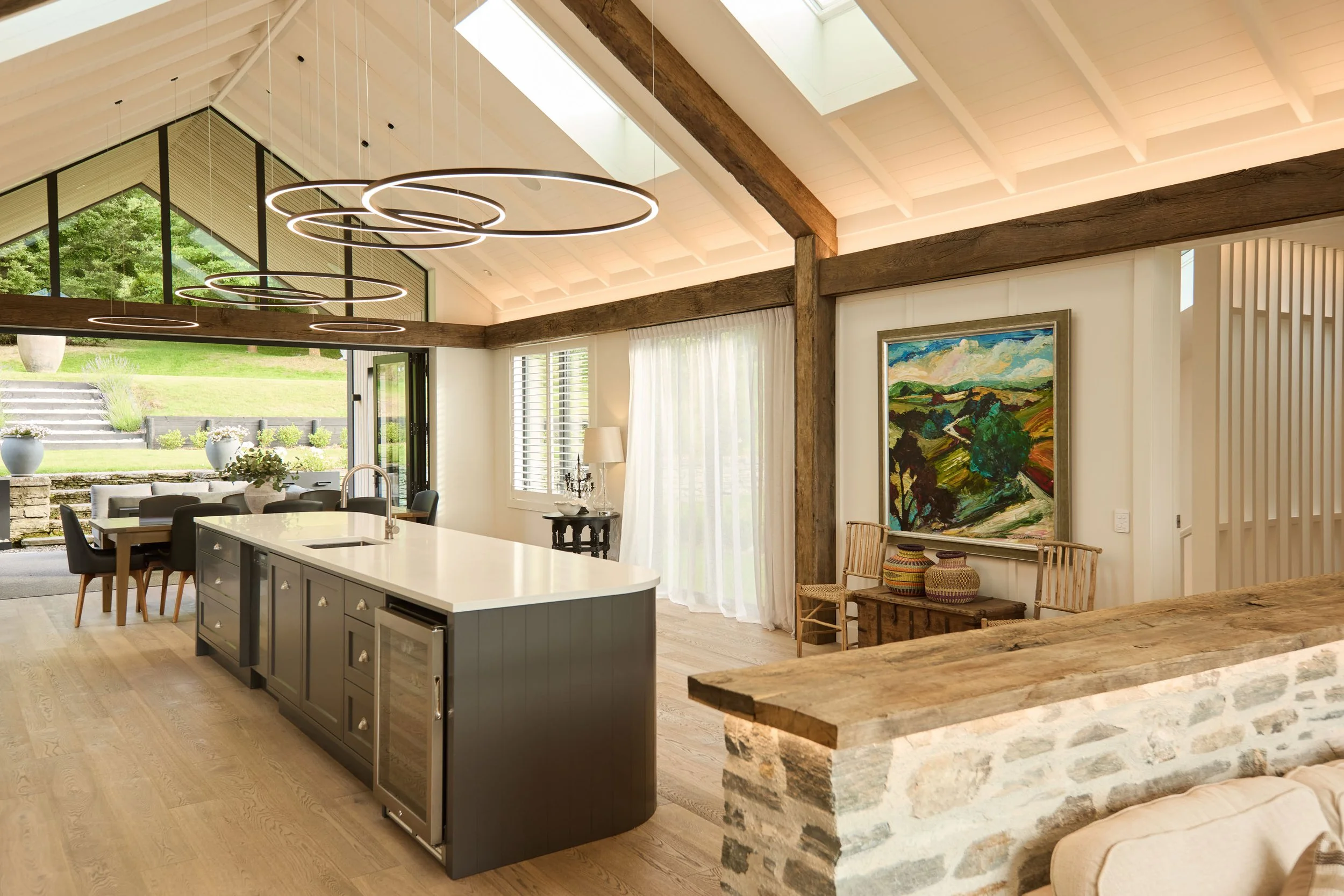 Reclaimed oak beam facings add warmth, texture and architectural character to this kitchen and living space, framing the ceiling, walls and interior features with aged European oak.