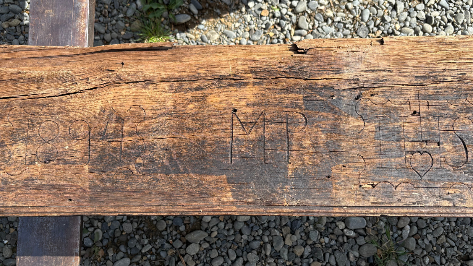 Reclaimed European oak beam showing historic markings, aged grain and original weathered surface character.