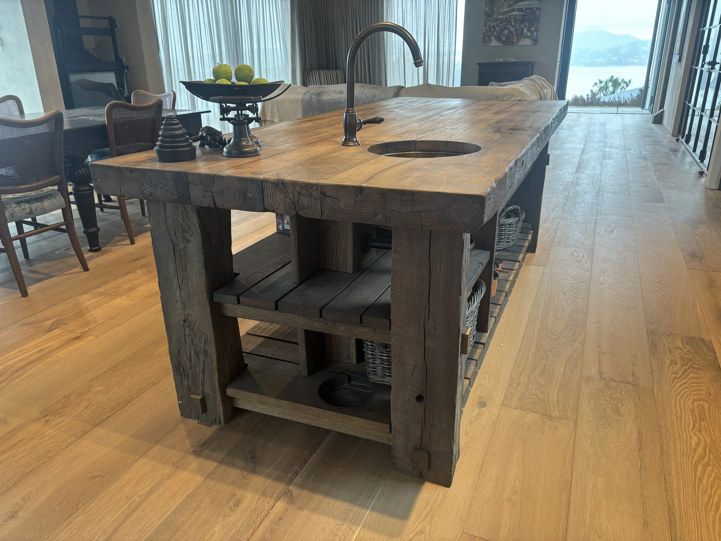 A rustic kitchen island with a wooden oak surface, antique oak is supplied for bespoke joinery and custom furniture projects.