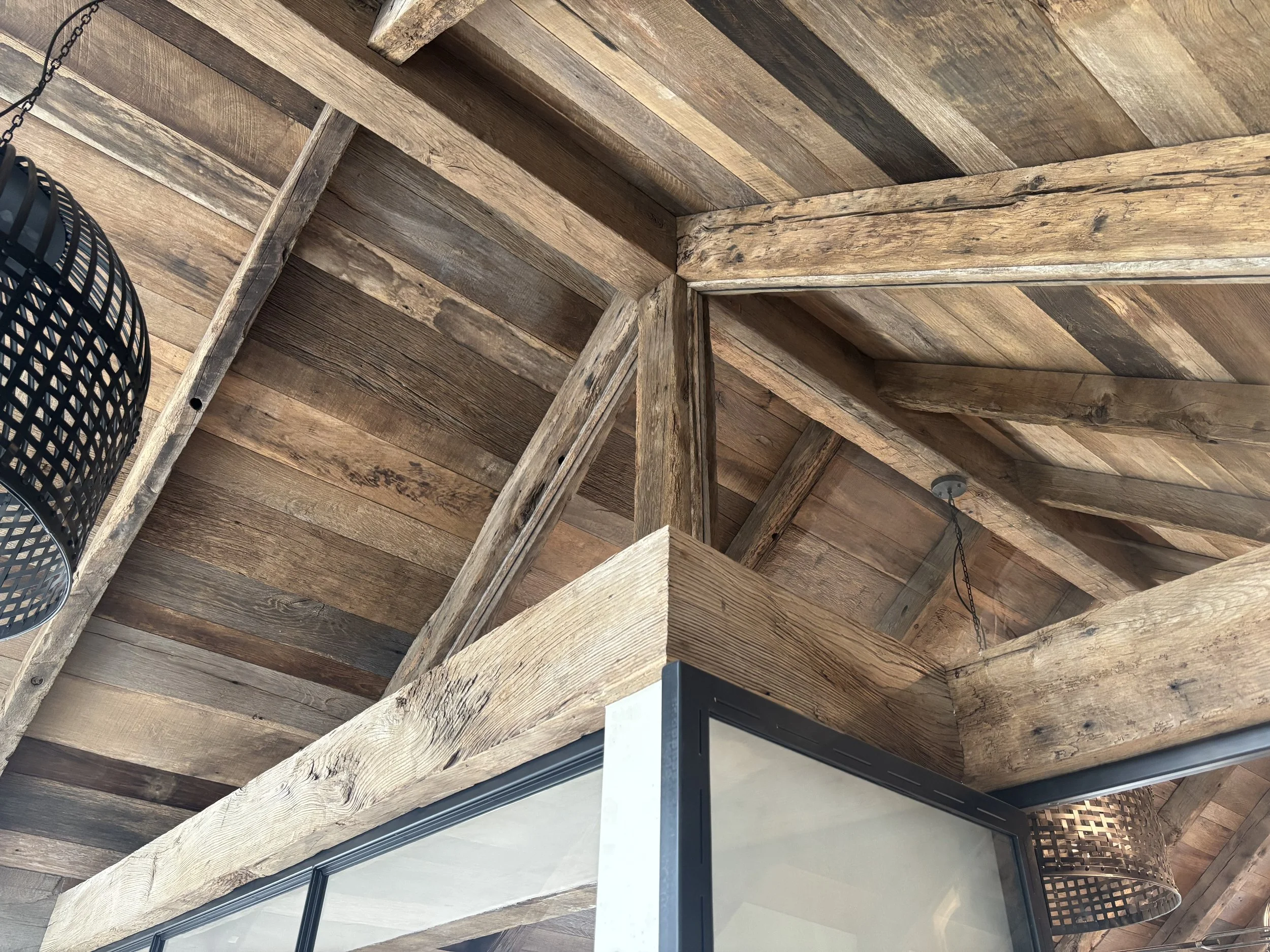 Reclaimed oak beam facing used to bring aged oak character to an existing architectural feature, with visible grain, cracks, tonal variation and worn surface texture.