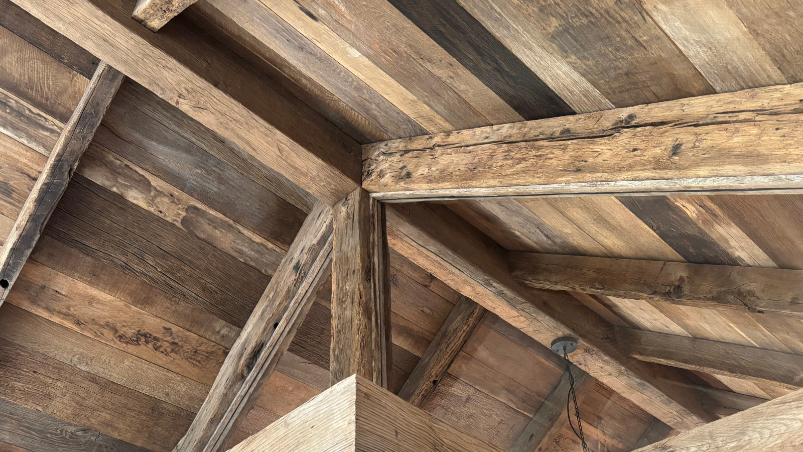 Reclaimed oak timber ceiling detail with exposed beams, aged surface texture and rustic architectural character.