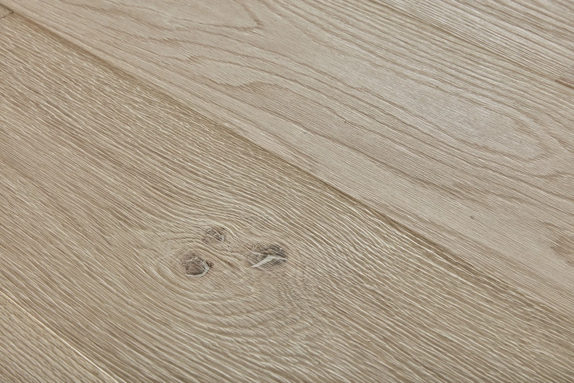 Close-up of a wooden surface, showing the grain, knots, and texture of the light-colored wood.