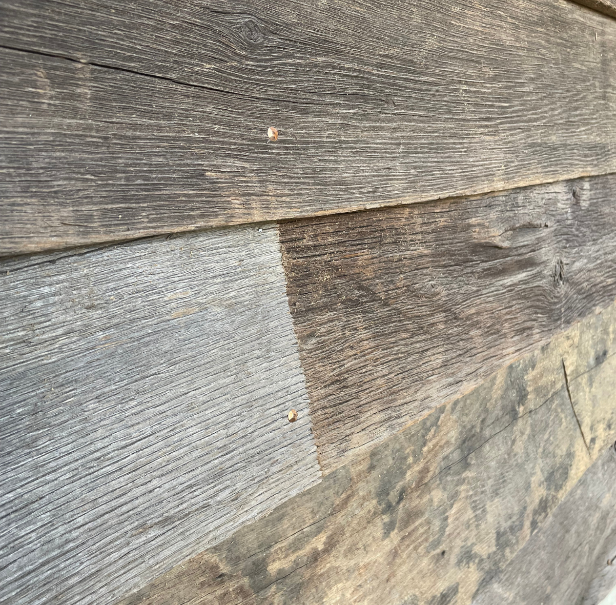 Close-up of reclaimed European oak exterior cladding showing natural grain, weathered texture and tonal variation.