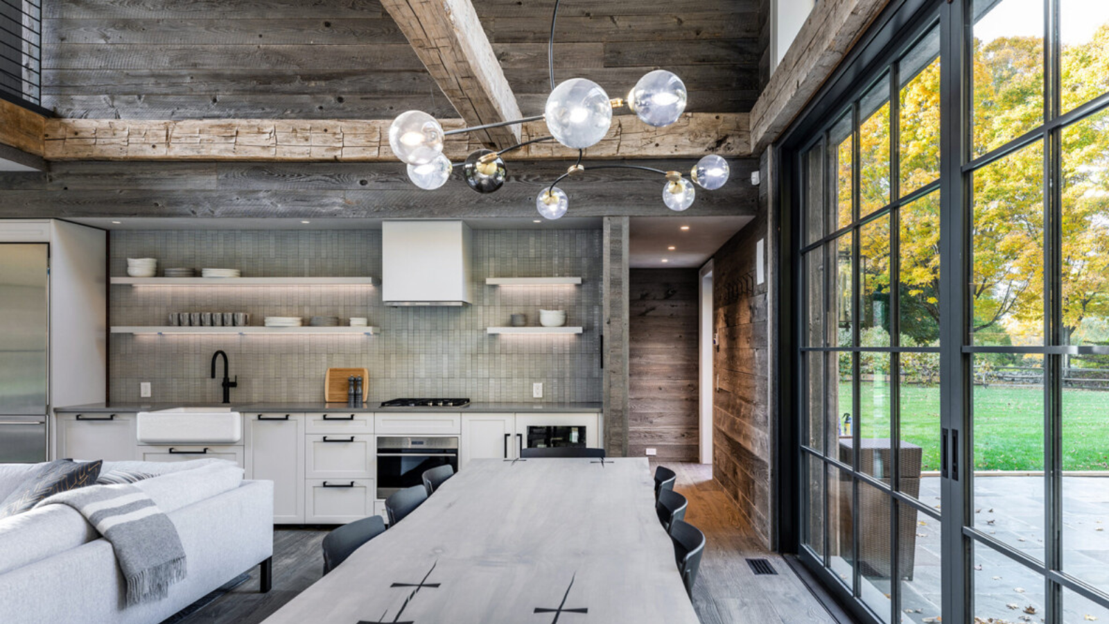 Modern kitchen and dining space featuring reclaimed European oak ceiling beams, timber wall lining and natural aged character.