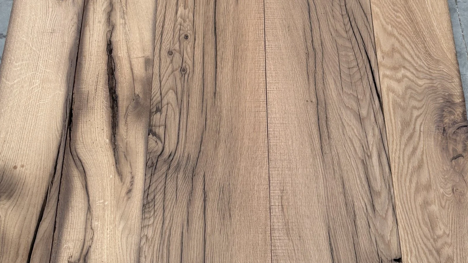 Reclaimed European oak flooring boards with natural grain, aged cracks, knots and soft tonal variation.
