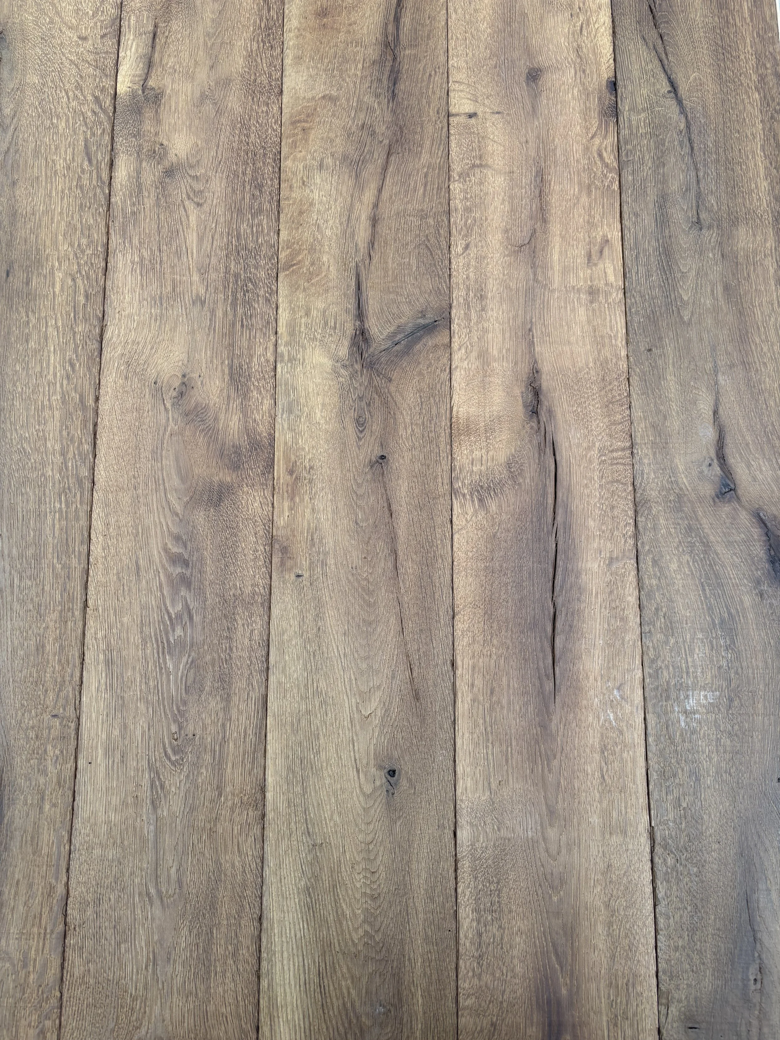 Wooden floor with vertical planks showing grain and knots.